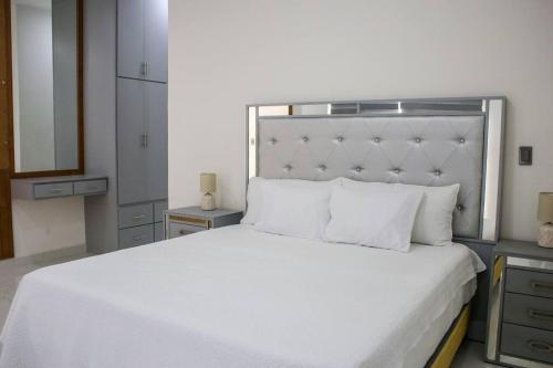 a bedroom with a large white bed and a mirror at Villa Costa Felix 5 in Puerto Peñasco