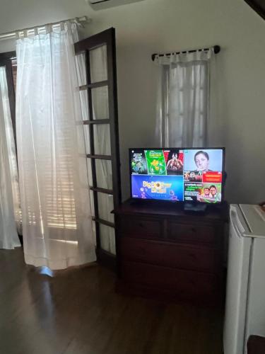 a flat screen tv sitting on top of a dresser at Jardim Secreto - Itaipava in Itaipava