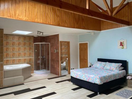 sypialnia z łóżkiem, prysznicem i wanną w obiekcie Amplia habitación con Jacuzzi w mieście Valdivia
