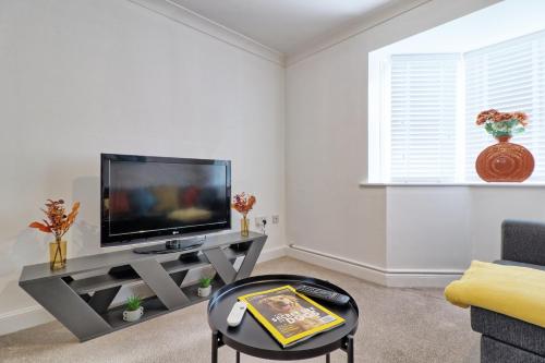 a living room with a flat screen tv on a table at Hythe Hill Home in Colchester