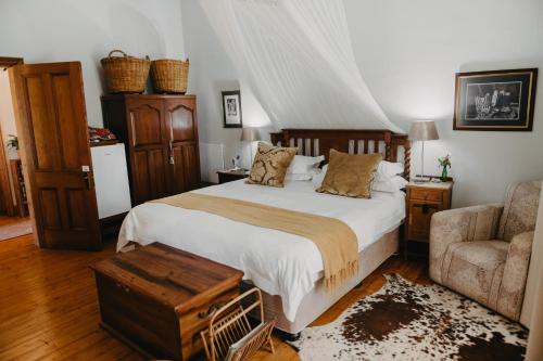 a bedroom with a bed and a couch and a chair at The Bethesda in Nieu-Bethesda