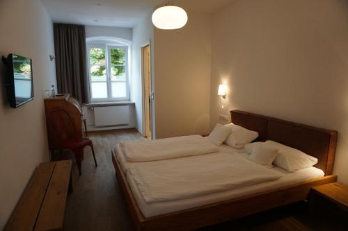 A bed or beds in a room at Gasthof und Metzgerei zur Post Peißenberg