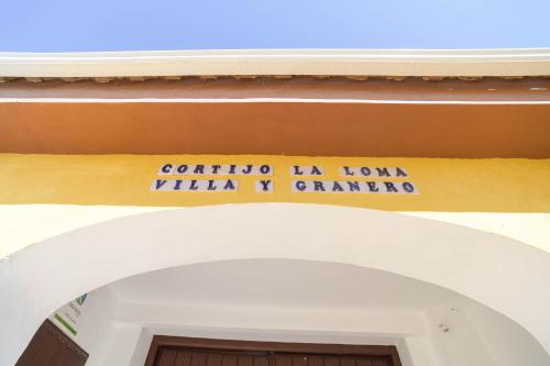 una entrada a un edificio con un letrero sobre una puerta en Casa Rural "compartida" La Loma, en Granada