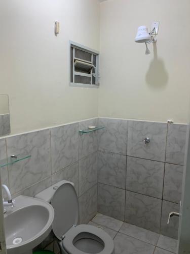 a bathroom with a toilet and a sink at 102 verão kit exclusiva in Brasilia