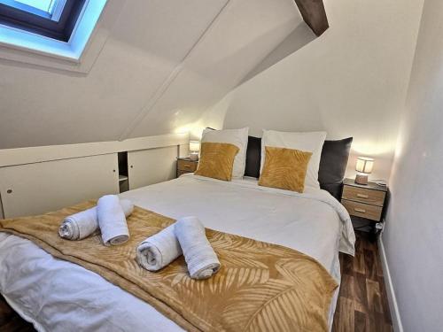 1 dormitorio con 1 cama blanca grande y toallas. en L'escapade Chelloise *Paris*, en Chelles