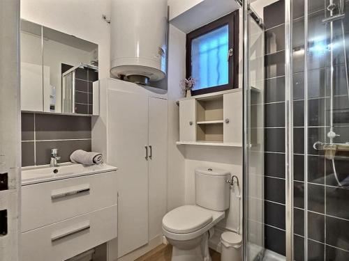 La salle de bains blanche est pourvue d'une douche et de toilettes. dans l'établissement L'escapade Chelloise *Paris*, à Chelles