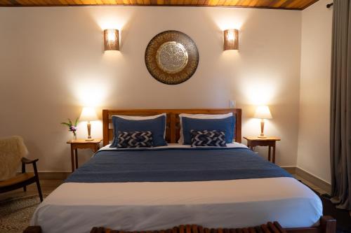 1 dormitorio con 1 cama grande con almohadas azules en Pousada Lua Clara, en Alto Paraíso de Goiás