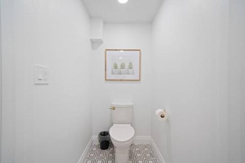 ein Badezimmer mit einem weißen WC mit einem Bild an der Wand in der Unterkunft Spanish Fork Retreat in Spanish Fork
