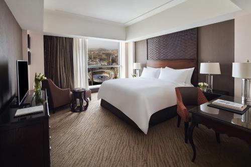 メッカにあるマッカ クロック ロイヤル タワー ア フェアモント ホテルの大きなベッドとデスクが備わるホテルルームです。