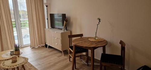 een woonkamer met een tafel en een televisie bij Apartamenty Paderewski 2 in Bielawa