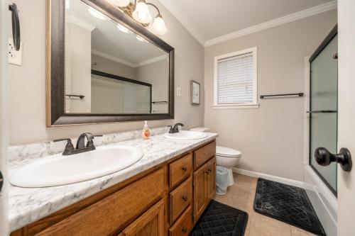 ein Badezimmer mit einem Waschbecken, einem Spiegel und einem WC in der Unterkunft Idas Ideal Homestead cozy 3Bed1Bath perfect for Work-Stay or Family Vacay in Morrilton