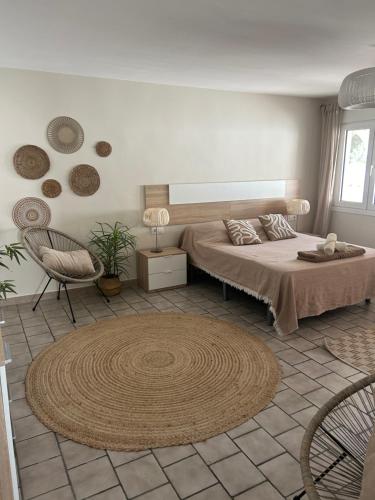 ein Schlafzimmer mit einem Bett, einem Stuhl und einem Teppich in der Unterkunft Villa Greyjoy - AzulenaCalpe in Calpe