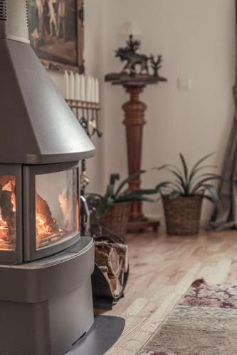 a fireplace in the corner of a living room at Målaskog gamla station 1 in Ryssby