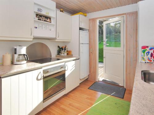 a kitchen with white cabinets and a door to a yard at Holiday Home Analia - 300m to the inlet by Interhome in Fur