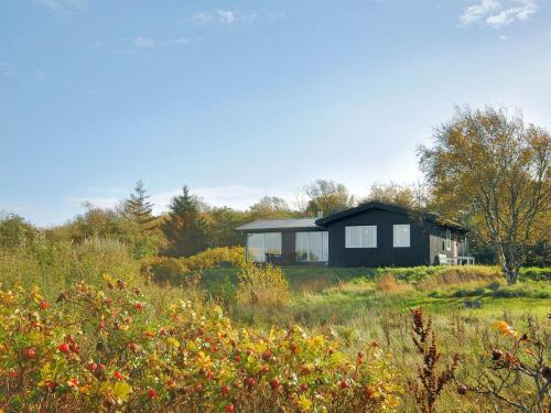 a black house on a hill in a field at Holiday Home Analia - 300m to the inlet by Interhome in Fur
