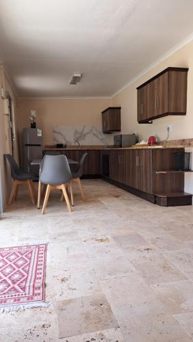 eine Küche mit Holzschränken sowie einem Tisch und Stühlen in der Unterkunft 11 Reservoir Road in Queenstown