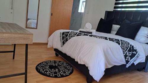1 dormitorio con 1 cama grande y 1 mesa en 11 Reservoir Road, en Queenstown