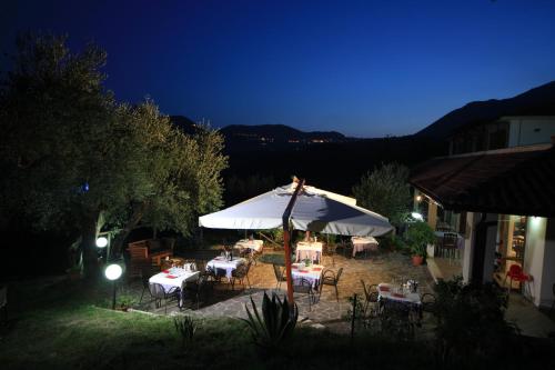 a group of tables and chairs under an umbrella at night at Tenuta Terre di Bosco Oasi di Relax nel Cilento in San Giovanni a Piro