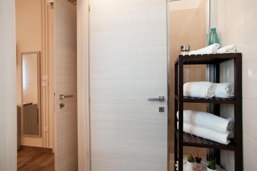 a room with a door and a shelf with towels at B&B Raffaello a Mare in Montesilvano