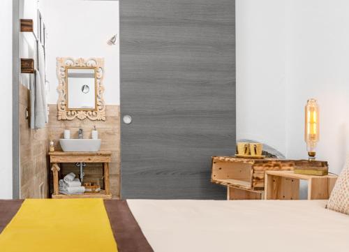 a bedroom with a bed and a sink and a mirror at B&B Les Chambres Rooms & Suite in Santa Teresa Gallura