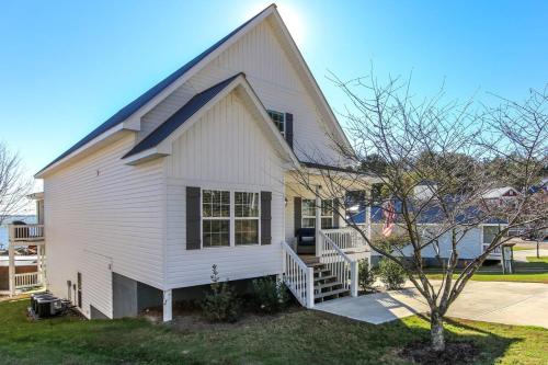 a white house with a porch and a tree at House #46 Grits Carlton Lakefront (no pets) in Centre