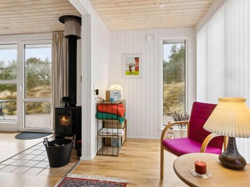 sala de estar con sofá púrpura y estufa de leña en Holiday Home Tammo - 900m from the sea in NW Jutland by Interhome en Torsted