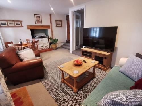 a living room with a couch and a coffee table at Cosy Cottage in a quaint village in North Devon. in Bideford