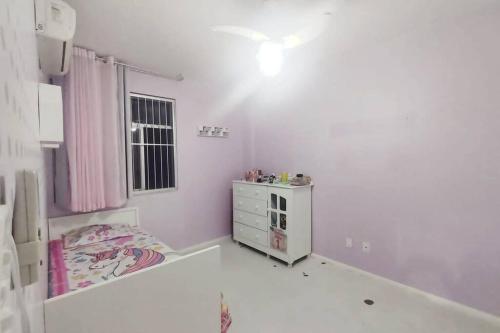 a white room with a bed and a dresser at Espaçoso em excelente localização na Barra in Salvador