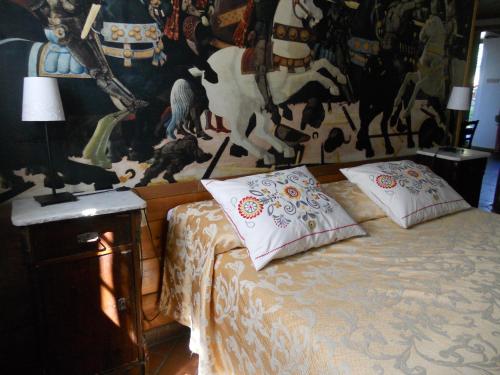 a bedroom with a bed with a painting on the wall at Agriturismo Le Macine in Florence