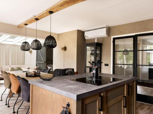 een open keuken en een woonkamer met een groot eiland bij Holiday Home Metbroekhuis Wellness de Luxe by Interhome in Vlagtwedde