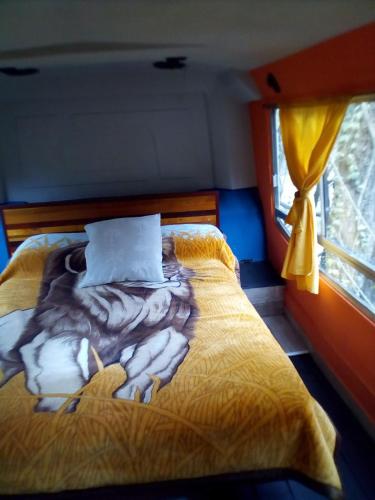 a large bed in a room with a window at Cabaña Bus LUYHANE in Yala
