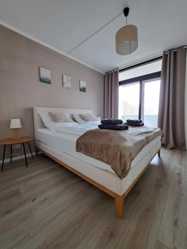 een groot bed in een slaapkamer met een groot raam bij Wander-Traum-Fewo in Bad Harzburg