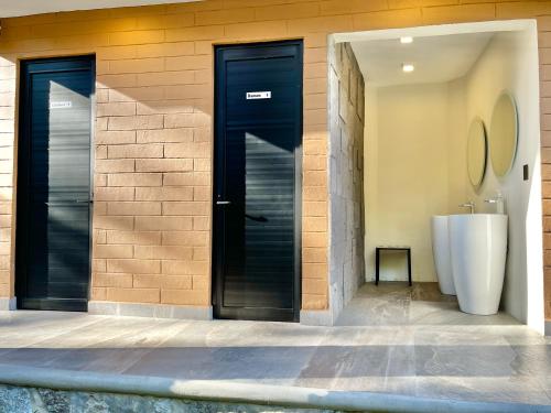 a bathroom with a black door and a white tub at Cabaña en Tapalpa, Cabaña Monarca in Tapalpa
