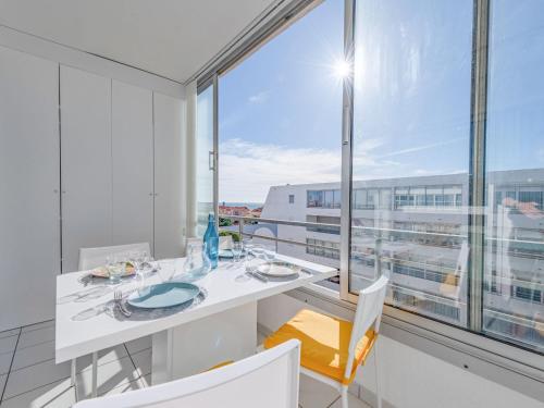 Un comedor con una mesa y un gran ventanal. en Apartment Grand Bleu by Interhome, en Le Barcarès