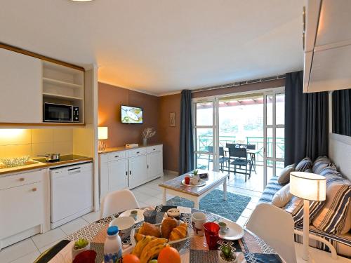 d'une cuisine et d'un salon avec une table et de la nourriture. dans l'établissement Studio Le Belvédère - R8 327 by Interhome, à Agay