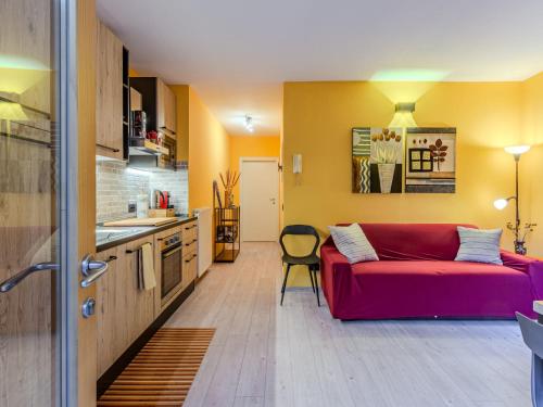 een woonkamer met een rode bank in een keuken bij Apartment Welcome 2 Riva by Interhome in Riva del Garda