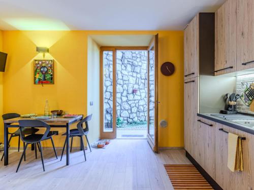 a kitchen with yellow walls and a table and chairs at Apartment Welcome 2 Riva by Interhome in Riva del Garda