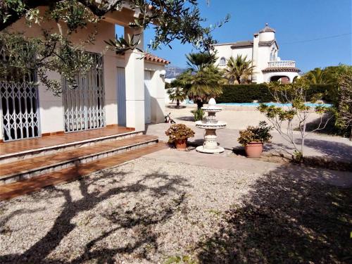 a house with a gate and a fountain in the yard at Villa Villa Olivos by Interhome in L'Ametlla de Mar