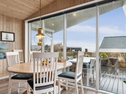 una sala da pranzo con tavolo e sedie di Holiday Home Gyrid - 150m from the sea in Djursland and Mols by Interhome a Rønde