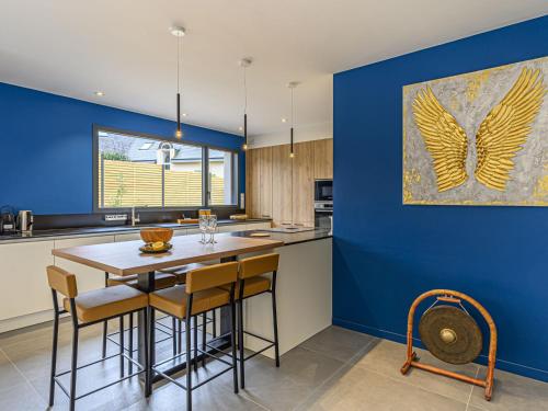 une cuisine avec un mur bleu, une table et des chaises dans l'établissement Holiday Home Villa du Golf by Interhome, à Baden