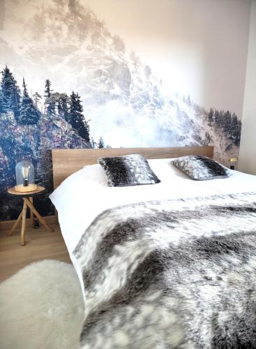une chambre avec deux lits et une fresque de montagne dans l'établissement Chalet Mondego, paisible et tout confort, à Gérardmer