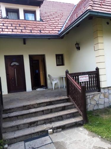 una casa con un porche con un cartel en las escaleras en JetSet Apartmani, en Zlatibor