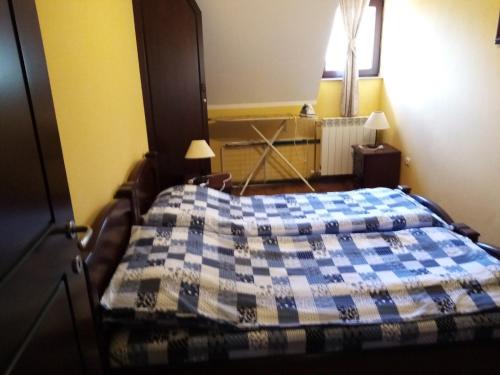 1 dormitorio con 1 cama con edredón azul y blanco en JetSet Apartmani, en Zlatibor