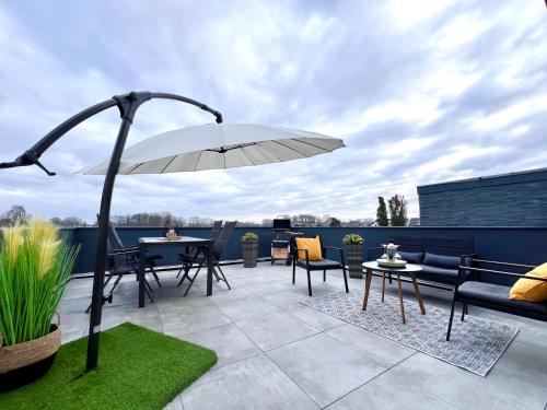 a patio with an umbrella and tables and chairs at Große Wohnung & Apartment Sauna & 4 Badezimmer Netflix in Petershagen