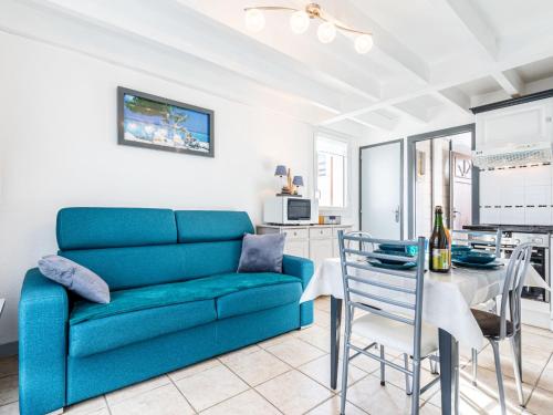 Una sala de estar con un sofá azul y una mesa. en Apartment Moulin de la Brunette-4 by Interhome, en Vaux-sur-Mer