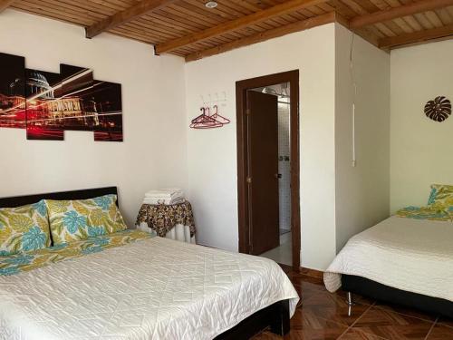 Hotel Padua في Chachagüí: غرفة نوم بسريرين في غرفة