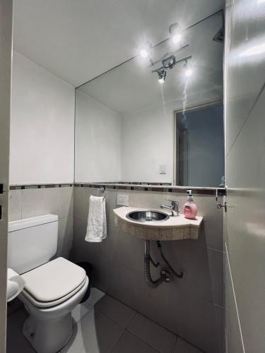 uma casa de banho com um WC, um lavatório e um espelho. em Moderno departamento en Nueva Córdoba em Córdoba