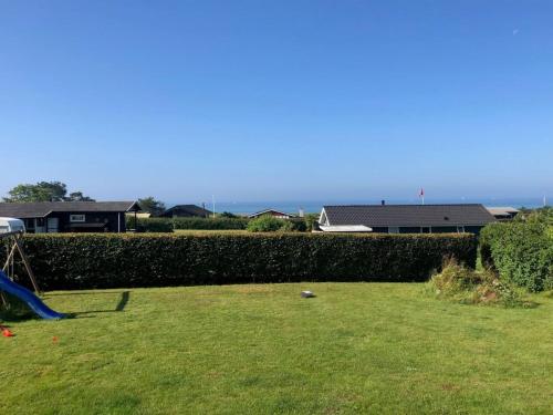 um quintal com uma cerca e um parque infantil em Holiday Home Rothger - 200m from the sea in SE Jutland by Interhome em Sønderby