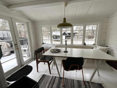 uma sala de jantar com mesa, cadeiras e janelas em Holiday Home Giertrud - 1-1km from the sea in Sealand by Interhome em Vig