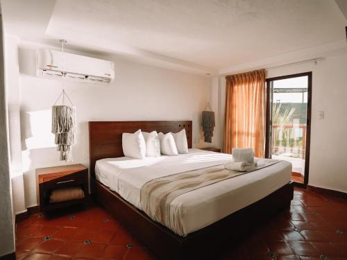 a bedroom with a large bed and a window at Hotel Rio Lagartos in Río Lagartos